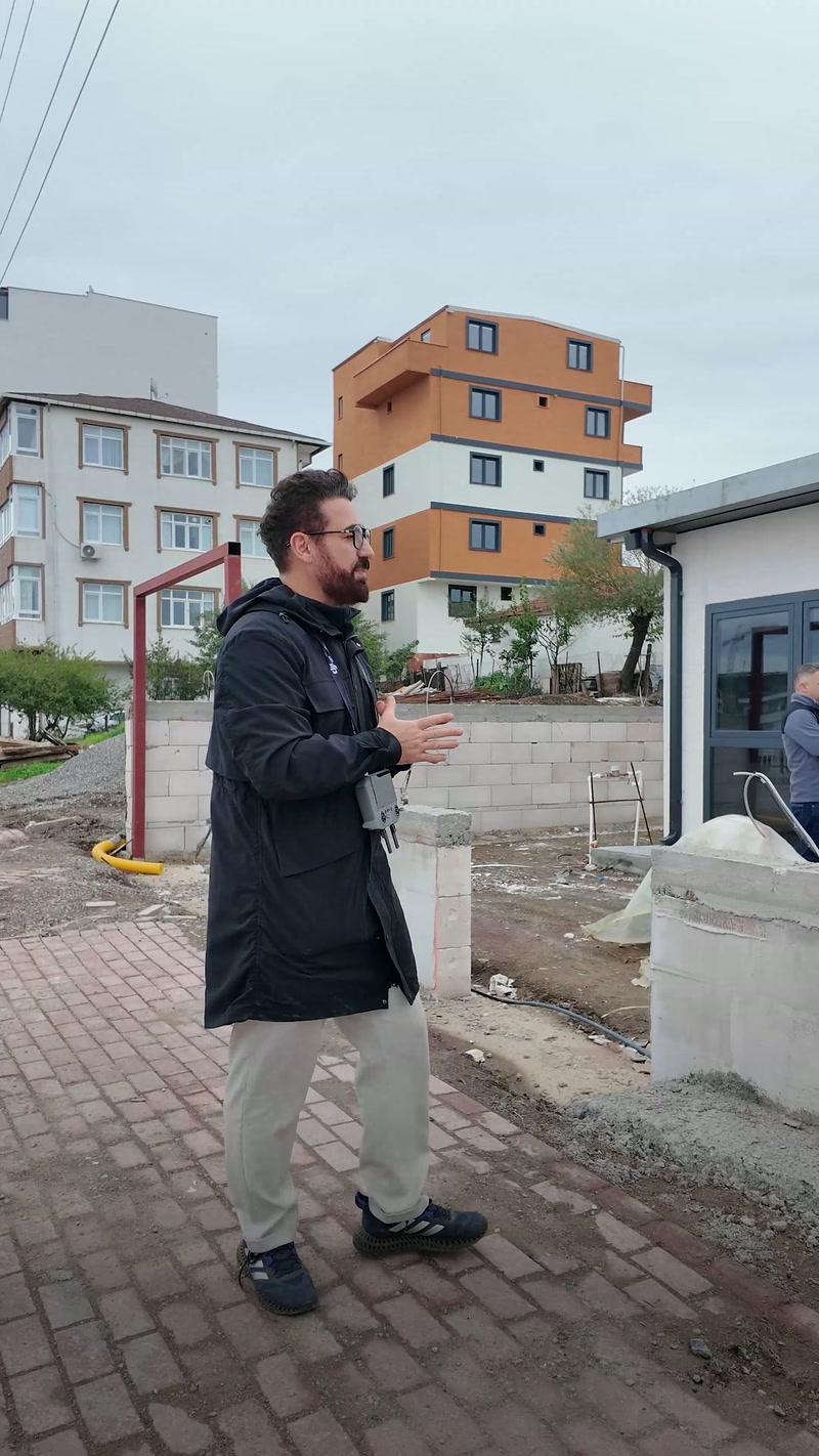 Uzman bina cephesi önünde saha ölçüm sürecini açıklıyor