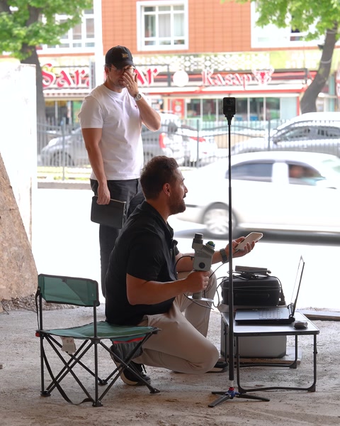 Açık havada iki kişi sandalyede röportaj kaydı yapıyor