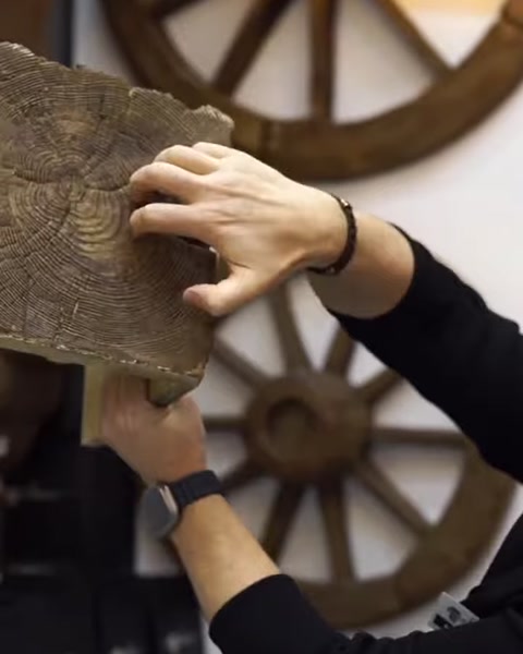 Kiriş yüzeyindeki budaklı ahşap dokusu elle inceleniyor