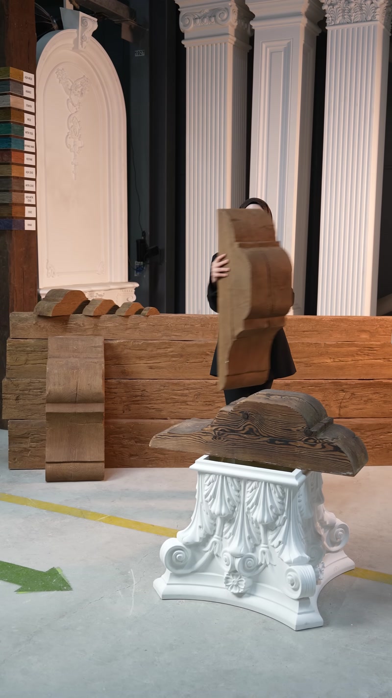 Büyük ahşap dokulu konsol modeli elde dikey tutuluyor.