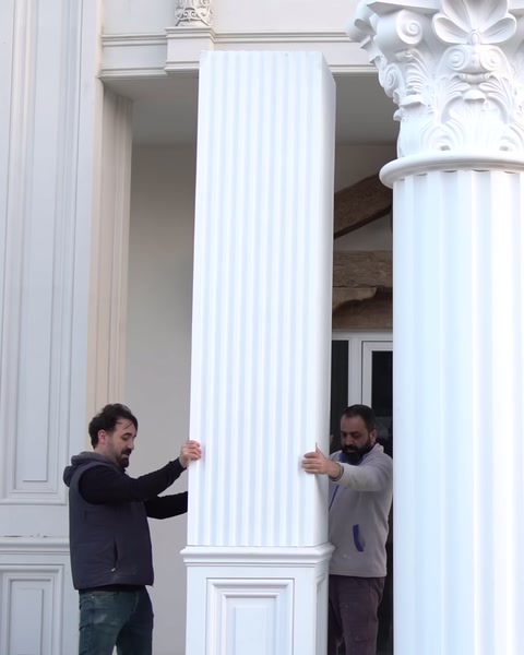 İki kişi sütun parçasını cepheye doğru taşıyor