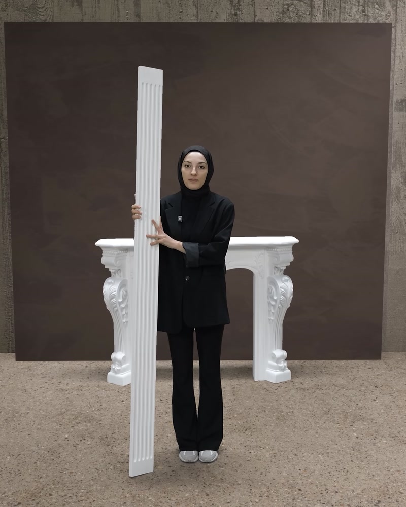 Plaster sütun ürünü elde tutularak şömine arkasına konumlandırılıyor