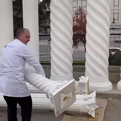 Usta, bezemeli sütun başlığı parçasını yerden kaldırıyor