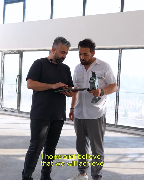 Pencereli geniş mekanda tabletle ölçüm çalışması yapılıyor