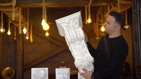 Büyük kabartmalı payanda modeli elde dikey olarak sergileniyor