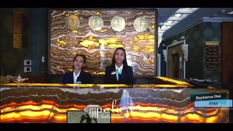 Kabartmalı duvar panosu önündeki dalgalı desenli resepsiyon bankosu