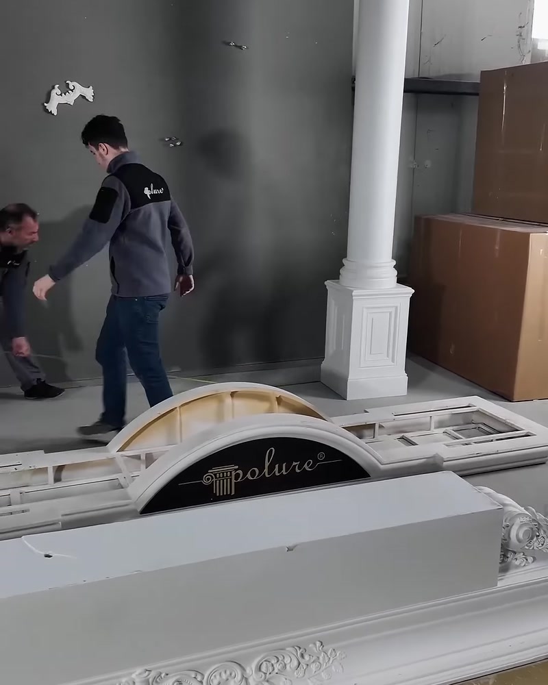 Usta, uzun beyaz sütunu kare kaidesi üzerinde konumlandırıyor.