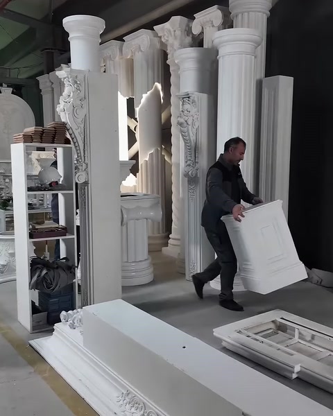 Usta, kabartmalı kare dekoratif paneli çalışma alanına taşıyor.
