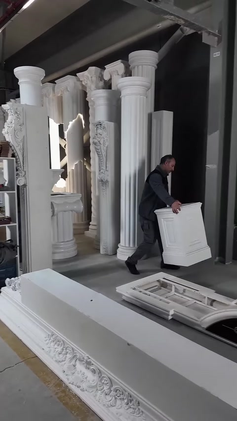 Görevli, dekoratif sütunun kare kaide parçasını uygulama alanına taşıyor.