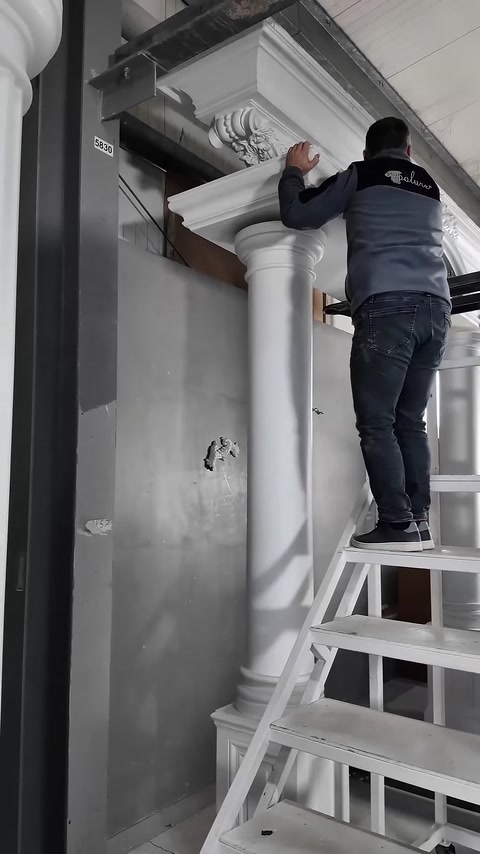 Merdivendeki usta, sütun başlığıyla üst tacın birleşimini elle ayarlıyor.
