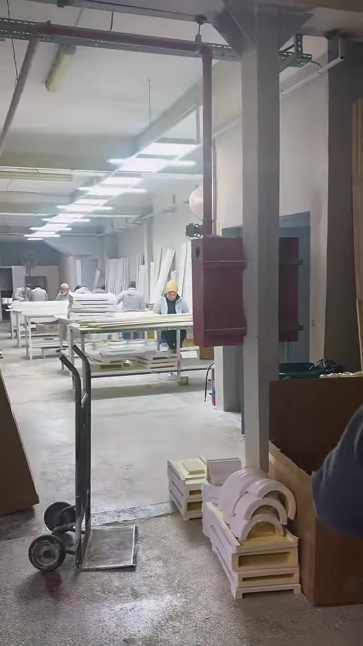 Geniş atölyede üretim masaları ve tamamlanmış dekoratif parçalar sergileniyor.