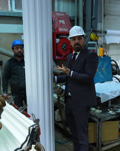 İşçi taze üretilmiş sütun profilini elleriyle tutuyor