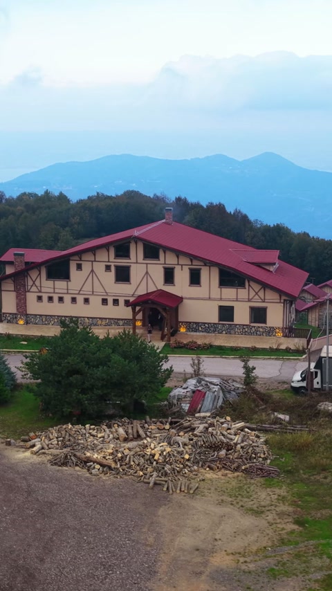 Kırmızı çatılı yapının cephe düzeni ve çevresi birlikte görülüyor