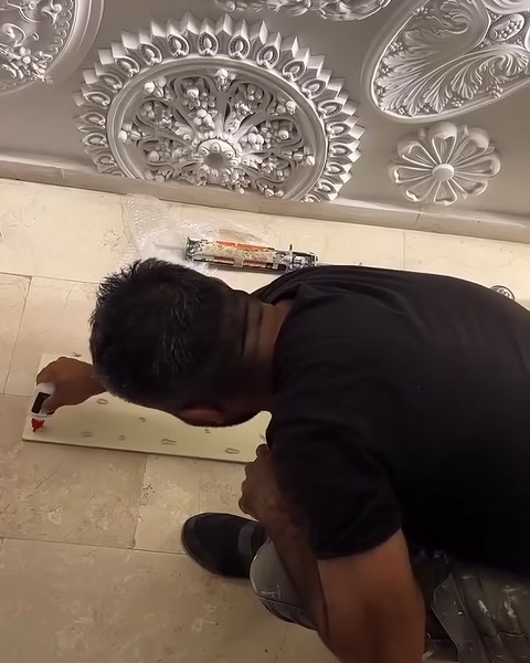 Usta, zemindeki panelin arka yüzüne hızlı yapıştırıcı uyguluyor