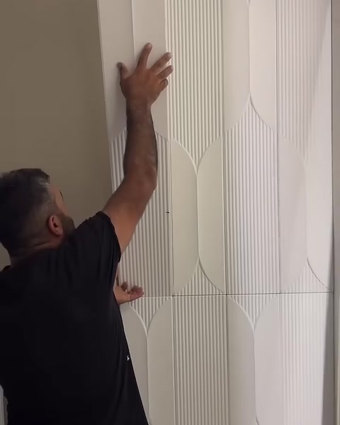 Usta, ilk desenli paneli duvara dikey biçimde yerleştiriyor