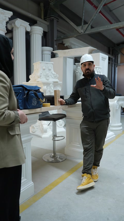 Üretim alanındaki sunumda farklı sütun modelleri arka planda görülüyor