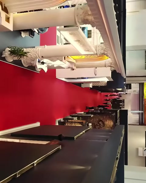 Kırmızı fonda sergilenen klasik sütun ve dekoratif heykel örnekleri
