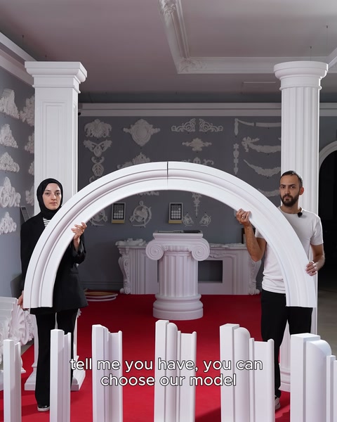İki kişi büyük yuvarlak kemer parçasını dikey tutuyor