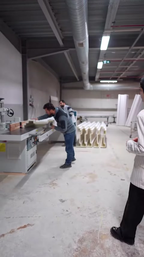 Üretim alanında çalışan, uzun profili kesim makinesine hazırlıyor.