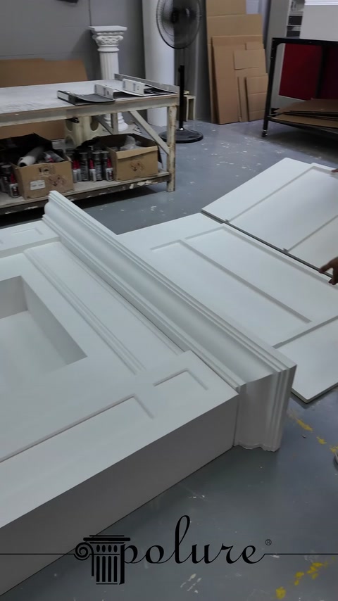 Beyaz şömine panellerindeki kademeli silmeler ve geometrik detaylar görülüyor.