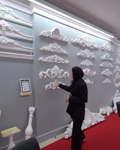 Duvara yerleştirilmiş farklı boyutlardaki poliüretan taç motifleri sergileniyor
