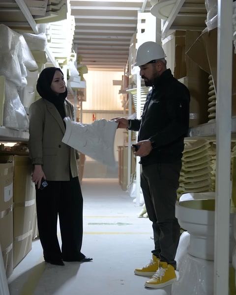 Kadın görevli, uzun kıvrımlı poliüretan profili yatay biçimde sergiliyor.