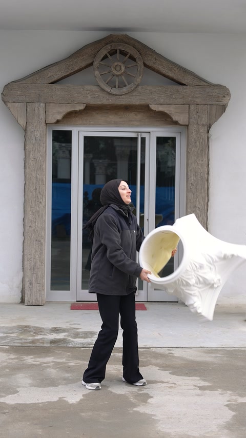 Uygulayıcı büyük kabartmalı sütun başlığını cephe önünde taşıyor.