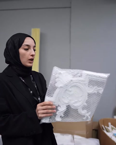 Paket içindeki dairesel kabartma motifi ön cepheden inceleniyor