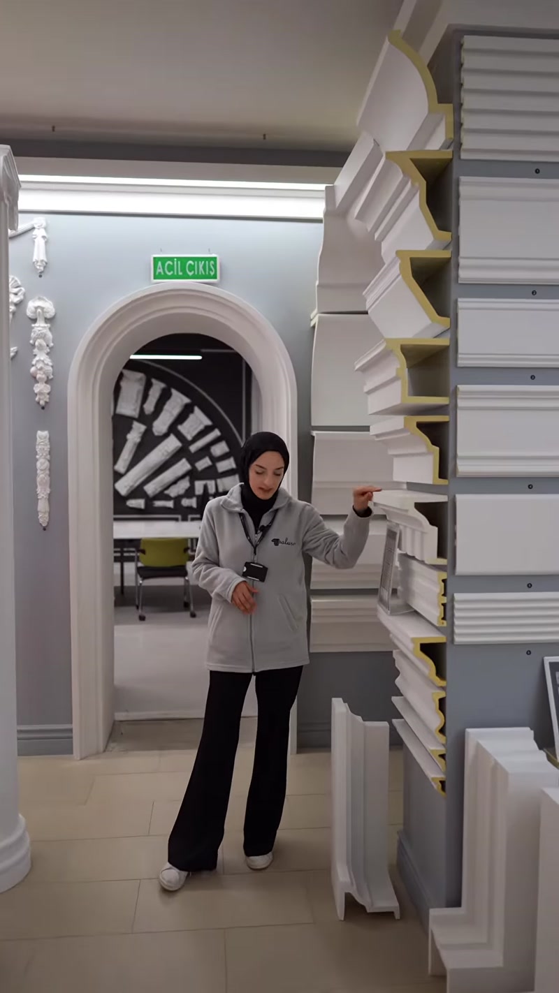Sunucu farklı kesitlere sahip söve modellerini rafta gösteriyor