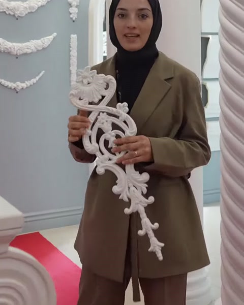 Sunucu, uzun beyaz poliüretan motif örneğini iki eliyle sergiliyor