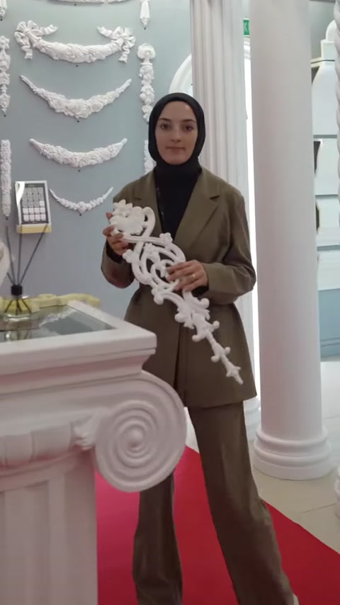 Sunucu, uzun ve kıvrımlı beyaz dekoratif motif modelini sergiliyor