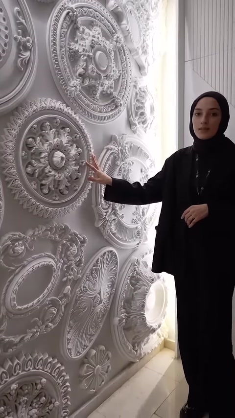 Sunucu, kabartmalı çiçek desenine sahip yuvarlak modeli gösteriyor