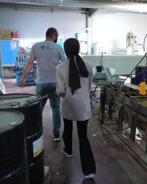 Çalışanlar CNC tezgahına doğru üretim alanında yürüyor