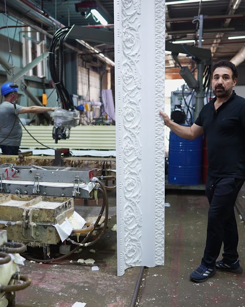 İşçiler desenli poliüretan profili üretim bandı boyunca taşıyor