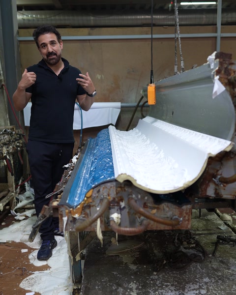 Çalışan, tamamlanan desenli kartonpiyer profiliyle başparmak işareti yapıyor