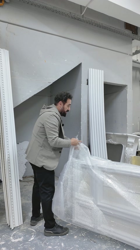 Beyaz panelin koruyucu ambalajı atölye ortamında tamamen açılıyor.