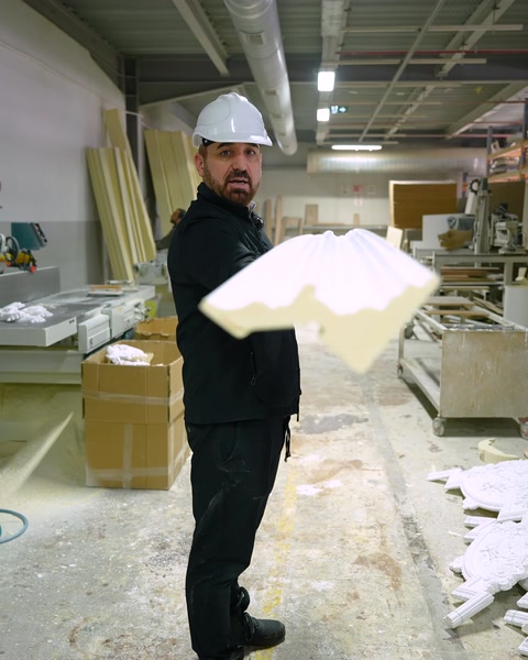 Kıvrımlı dekoratif kartonpiyer parçası incelenip gösteriliyor