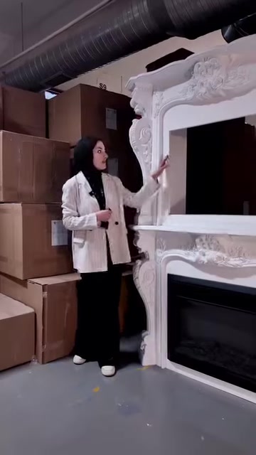 Kabartmalı beyaz şömine çerçevesi çapraz açıdan inceleniyor