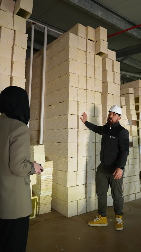 Fabrika alanında üst üste dizilmiş açık renkli üretim blokları