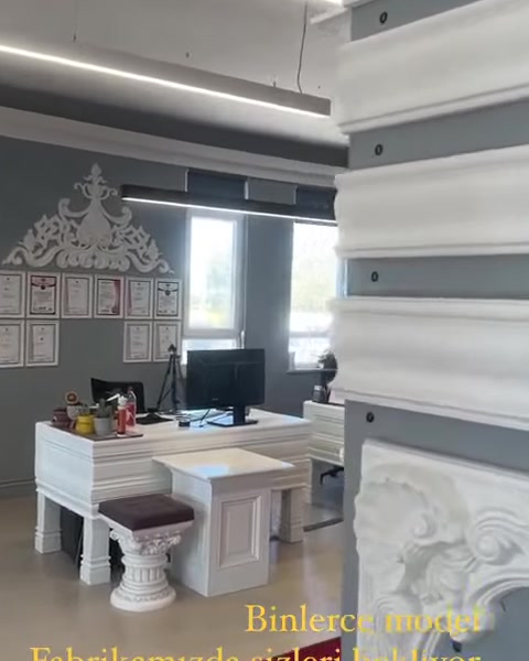 Beyaz düz profiller ve kabartmalı şömine detayı yakından görülüyor.