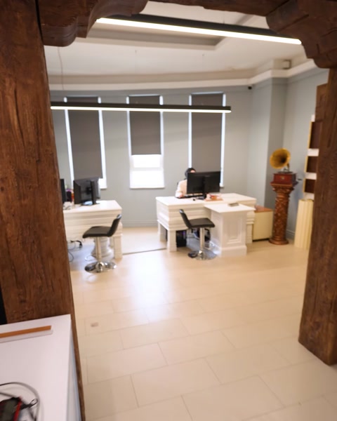 Ofis koridorunda ahşap kirişli tavan ve sütun süslemeleri görülüyor