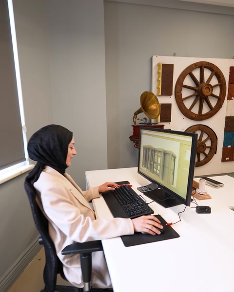 Tasarımcı ofis masasında çift monitörle proje üzerinde çalışıyor