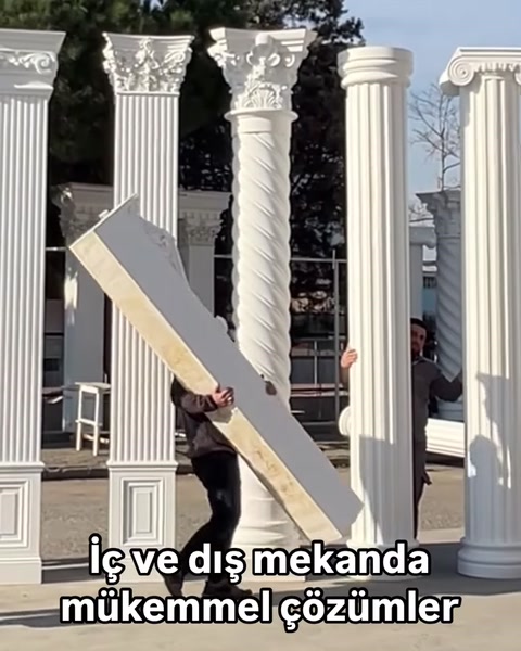 Çalışan uzun dikdörtgen dekoratif yapı parçasını taşıyor