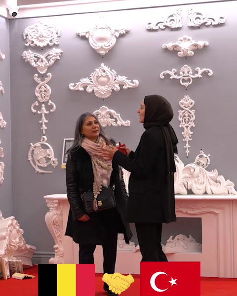Dekoratif rölyeflerle düzenlenmiş showroom duvarında ürün incelemesi