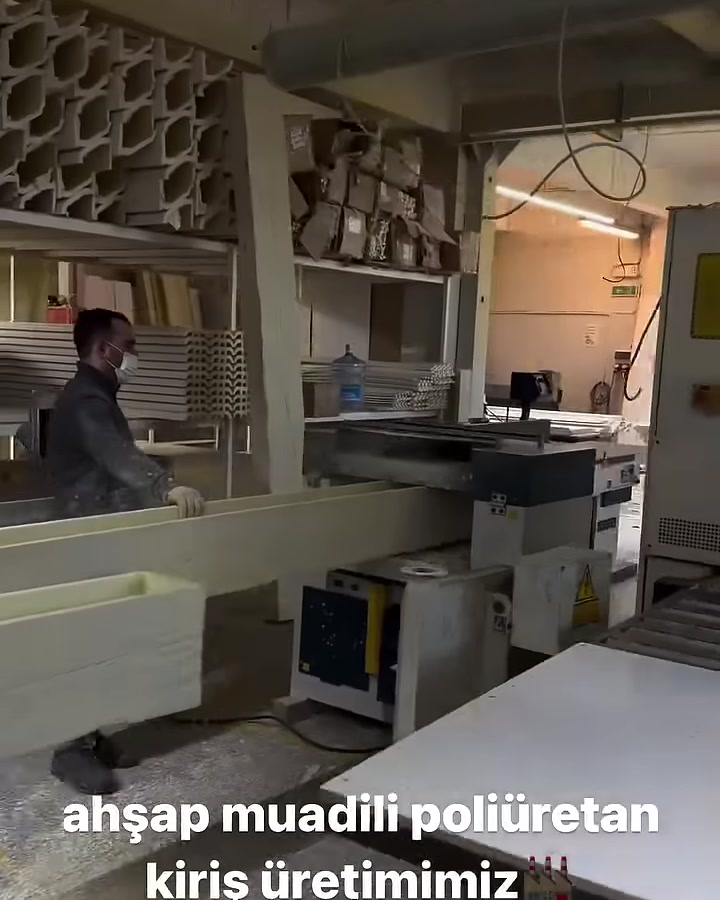 Çalışan uzun poliüretan kiriş profilini üretim makinesinde yönlendiriyor