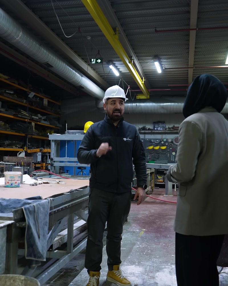 Üretim salonunda kalıp ve profiller arasında çalışan personel