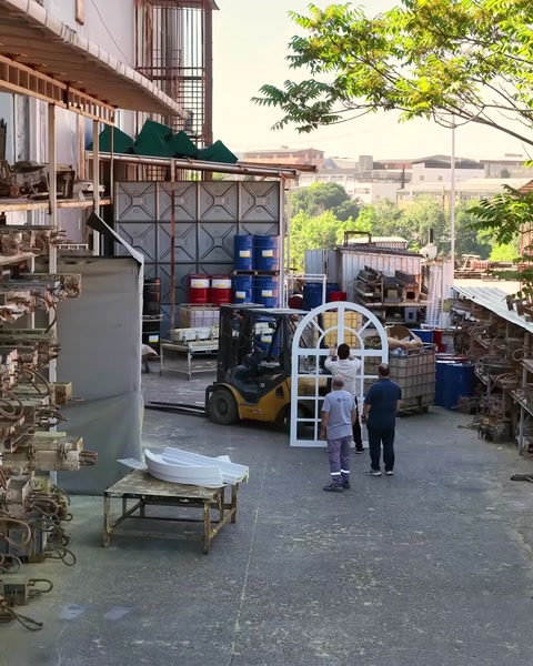 Fabrika sahasında iki çalışan malzeme taşıma hazırlığı yapıyor