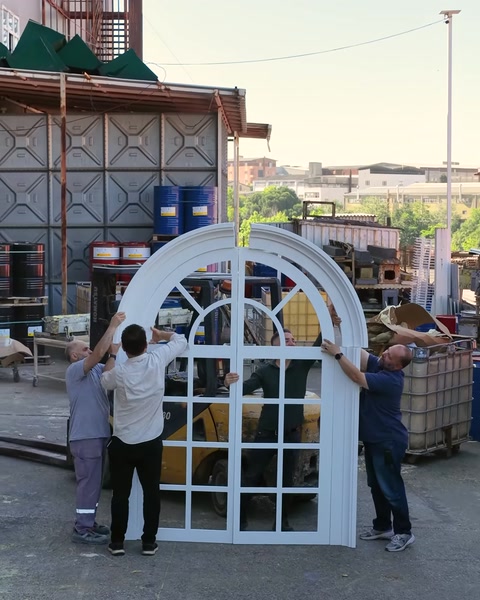 İki işçi kemerli pencere sövesini dikey konuma kaldırıyor