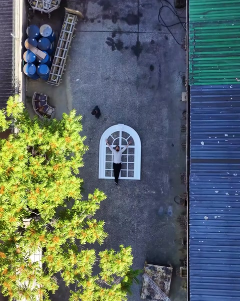 Havadan uzak çekimde küçük pencere modeli ağaç yanında görünüyor