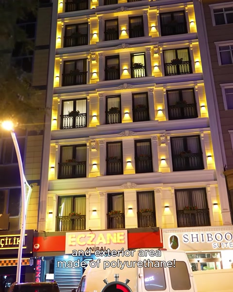 Aksam vakti aydinlatilmis cok katli beyaz cephe binasi